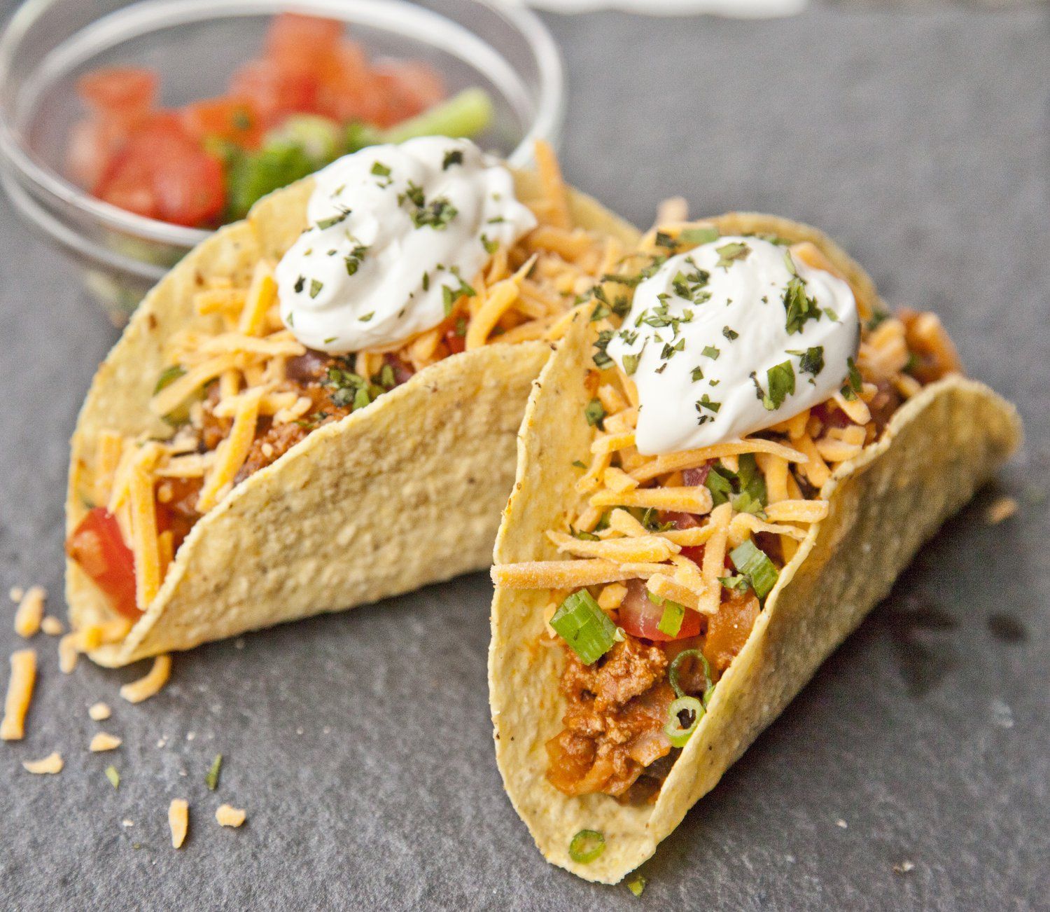 Beef & Black Bean Tacos topped with cheese, sour cream, scallions, ...